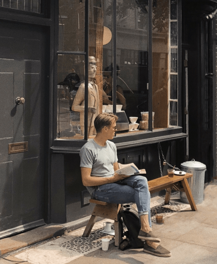 Hombre con gafas de sol leyendo en la calle